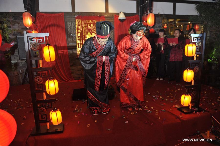 Peng Yong (L) and his bride Chen Yuanyuan (R) extend their gratitude towards friends and relatives during a traditional Chinese wedding in Guiyang, capital of southwest China's Guizhou Province, Nov. 19, 2012. The traditional Chinese wedding, pursuant to the etiquettes of the Zhou Dynasties (1046-256BC), sees a resurgence in recent years as the sense of identity grows among modern Chinese couples. (Xinhua/Ou Dongqu) 