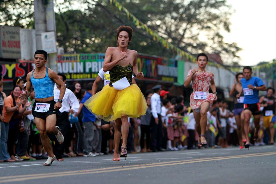 Men in different high heels run hard in the competition. (Xinhua/Rouelle Umali)