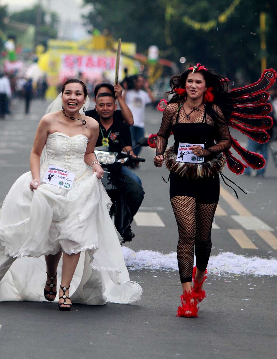 Two female runners run in black and white. (Xinhua/Rouelle Umali)