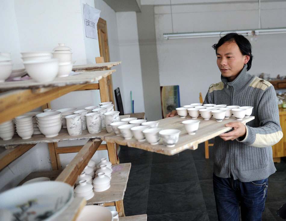 Liu Zhen carries the porcelain adobes in his studio at the Chengdexuan Porcelain Co.,Ltd, in Jingdezhen of east China's Jiangxi Province, March 8, 2012. (Xinhua/Zhou Ke)