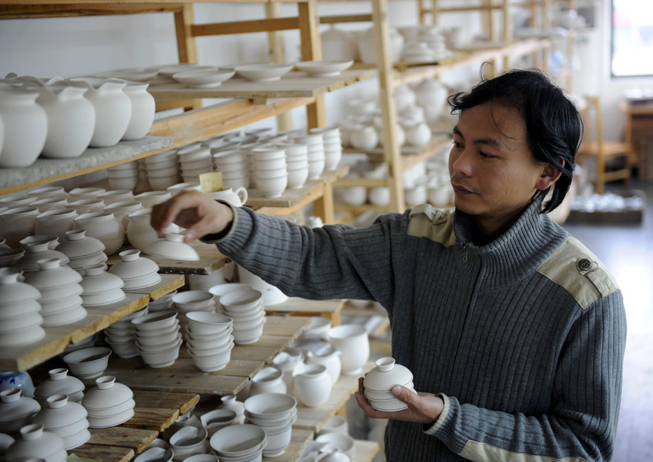Liu Zhen orders the porcelain adobes in the Chengdexuan Porcelain Co.,Ltd, in Jingdezhen of east China's Jiangxi Province, March 8, 2012. (Xinhua/Zhou Ke)
