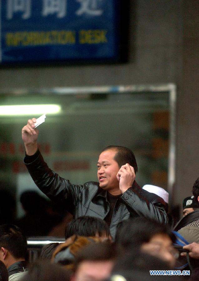 File photo taken on Jan. 20, 2006 shows a man talks to his family after he buys a ticket for home journey in Zhengzhou Railway Station in Zhengzhou, capital of central China's Henan Province. (Xinhua/Wang Song)