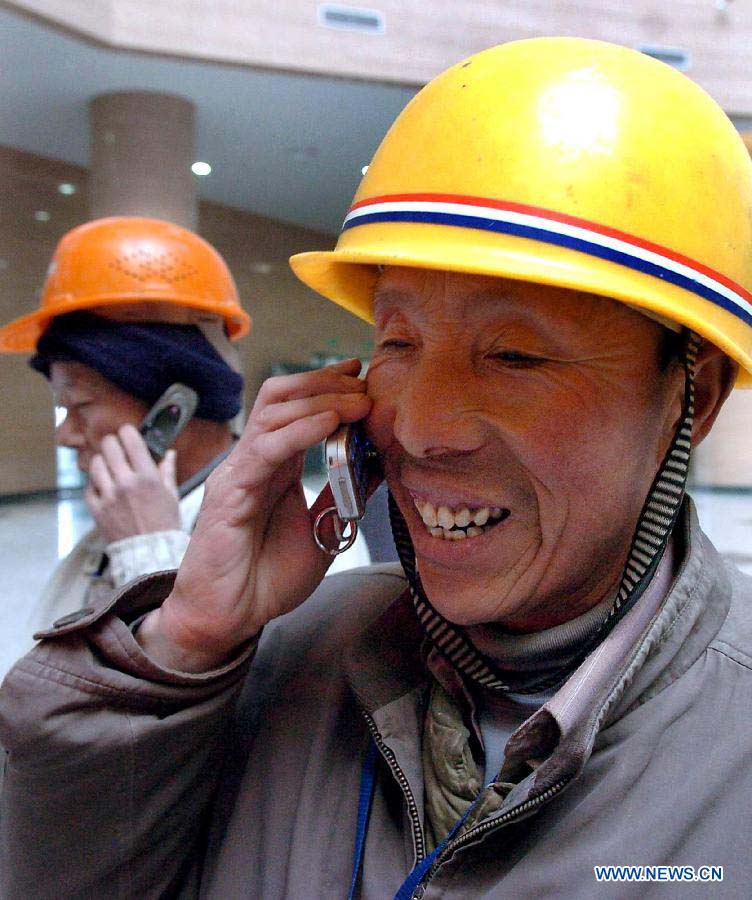 File photo taken on Jan. 26, 2006 shows that a construction worker makes a phone call to his family in Zhengdong District of Zhengzhou, capital of central China's Henan Province.(Xinhua/Wang Song)