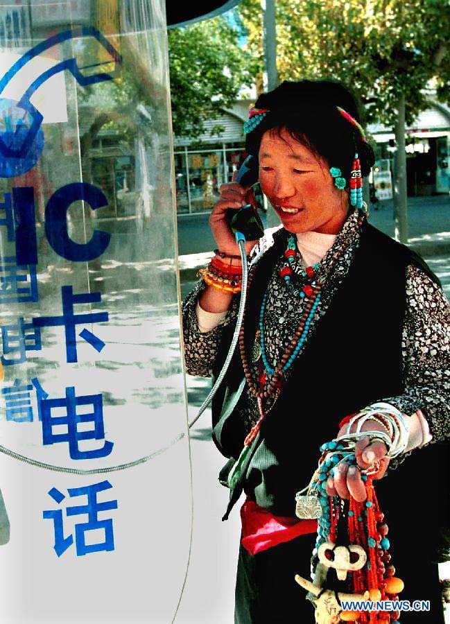 File photo taken in August, 2000 shows that a woman of Tibetan ethnic group uses an IC card telephone by a street side in Lhasa, capital of southwest China's Tibet Autonomous Region. (Xinhua/Wang Song)