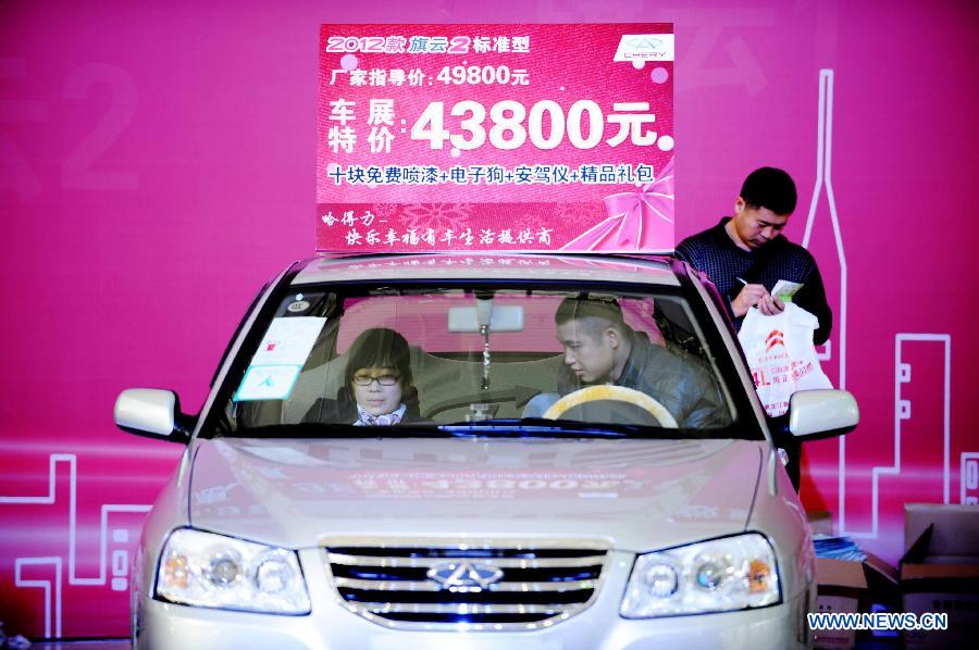Visitors experience an economy car during the 2012 Harbin Autumn Automobile Exhibition in Harbin, capital of northeast China's Heilongjiang Province, Nov. 20, 2012. Economy cars presented on the week-long exhibition with a price under 100,000 yuan (about 16,030 U.S. dollars) attracted lots of attention. (Xinhua/Wang Jianwei)
