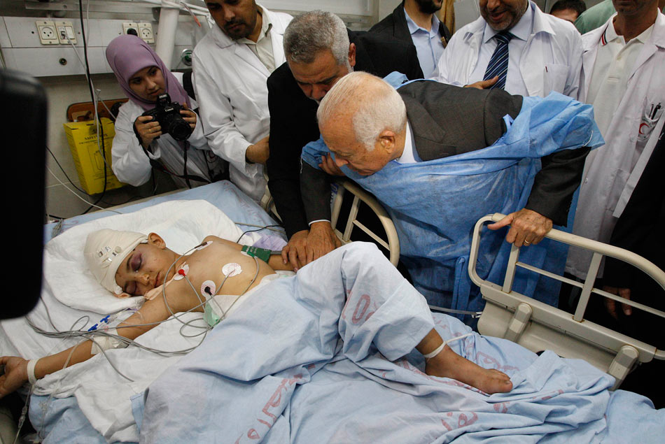 The Secretary General of the Arab League Nabil al-Arabi (C) and Hamas Prime Minster Ismail Haniya (3rd, L) visit a Palestinian child injured in Israeli airstrikes in a hospital in Gaza City, on Nov. 20, 2012. (Xinhua/AFP)
