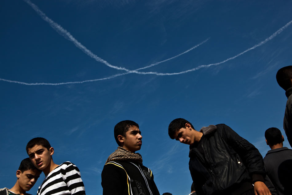 Vapor trails from Israeli F16 fighter jets are seen during a funeral in Gaza City, Nov. 20, 2012. Hamas-run Ministry of Health said the death toll since Wednesday in the Gaza Strip has climbed to 130 and more than 1,000 people were wounded in the ongoing Israeli aerial operation on the coastal enclave. (Xinhua/Chen Xu)