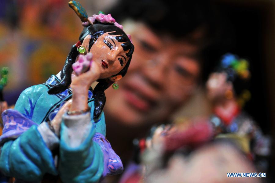 Li Lingxiu shows her clay sculptures in Lanzhou, capital of northwest China's Gansu Province, Nov. 20, 2012. The retired worker Li Lingxiu created 30 clay sculptures of characters in the ancient Chinese novel classic "A Dream of the Red Chamber". (Xinhua/Chen Bin) 