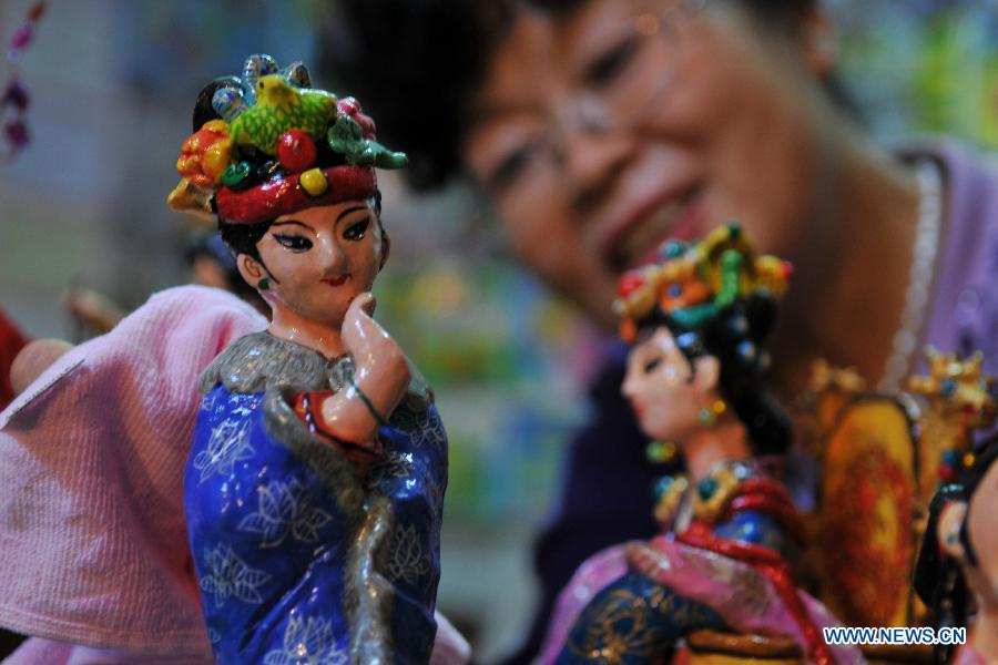 Li Lingxiu cleans her clay sculptures in Lanzhou, capital of northwest China's Gansu Province, Nov. 20, 2012. The retired worker Li Lingxiu created 30 clay sculptures of characters in the ancient Chinese novel classic "A Dream of the Red Chamber". (Xinhua/Chen Bin) 