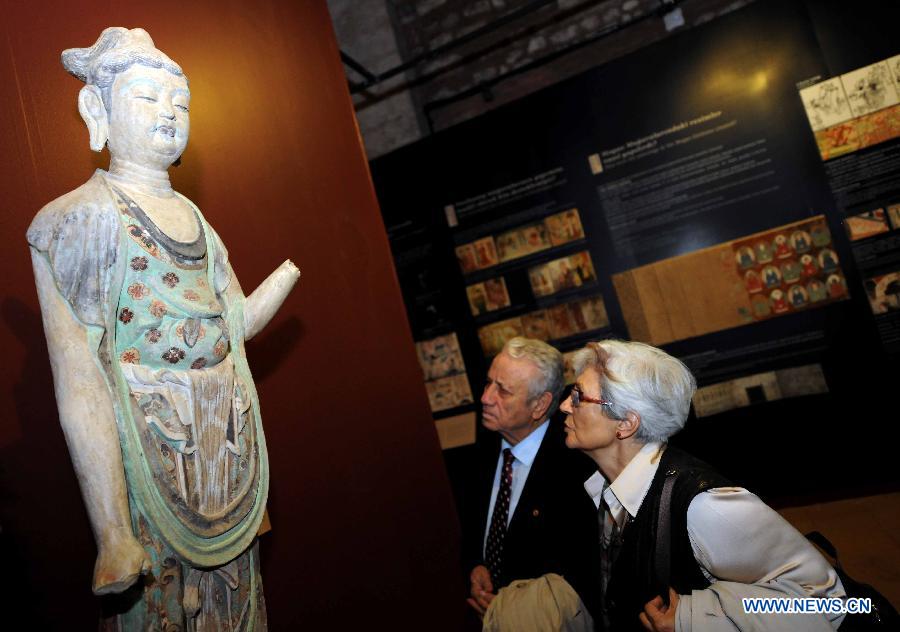 Visitors watch the duplicate of a statue at the"The Colors of Dunhuang: A Magic Gateway to the Silk Road" exhibition held in Mimar Sinan University in Istanbul of Turkey, on Nov. 20, 2012. The Exhibition kicked off here on Tuesday. (Xinhua/Ma Yan)