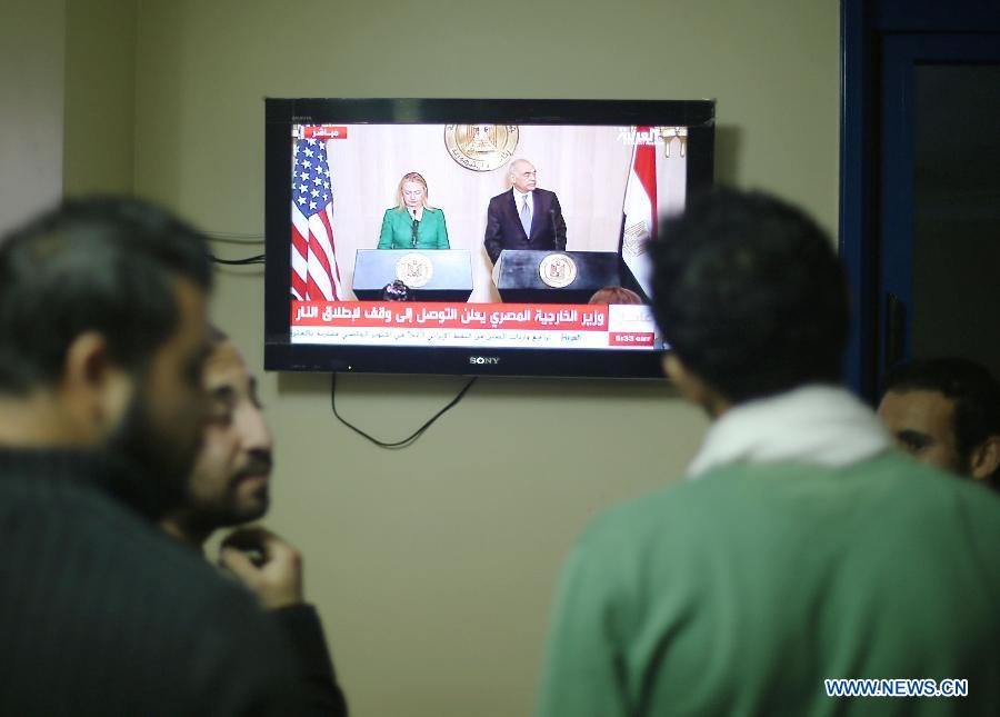 Palestinians watch TV for a press conference of U.S. Secretary of State Hilary Clinton and Egyptian Foreign Minister Mohamed Kamel Amr, Nov. 21, 2012. Mohamed Kamel Amr announced here that the ceasefire between Israel and Gaza militant groups will take effect at 9:00 p.m. local time ( 1900 GMT) on Wednesday. (Xinhua/Wissam Nassar) 