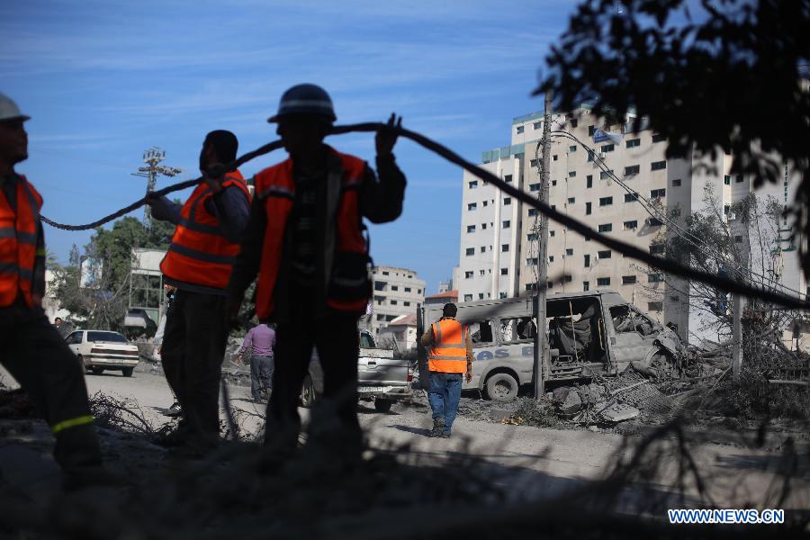 Palestinian electricity workers fix power cords at the destroyed compound of the internal security ministry in Gaza City after it was targeted by an overnight Israeli air strike on Nov. 21, 2012. (Xinhua/Wissam Nassar) 