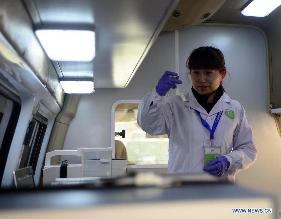 A researcher conducts food test in the newly-developed intelligent vehicle for food detection in Lanzhou, capital of northwest China's Gansu Province, Nov. 21, 2012. The intelligent vehicle can conduct various kinds of food tests on site. (Xinhua/Zhang Meng) 