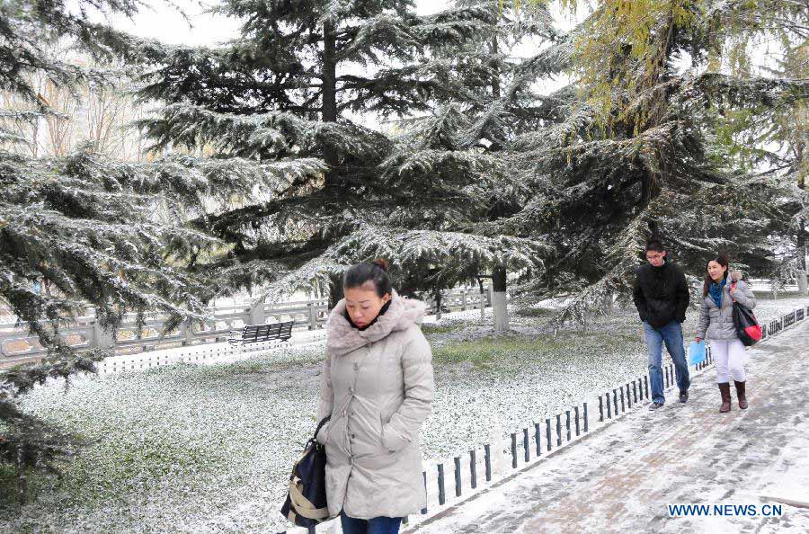 Pedestians walk in snow in Lanzhou, capital of northwest China's Gansu Province, Nov. 22, 2012. The province was hit by snow and temperature decrease on Thursday.(Xinhua/Fan Peishen) 
