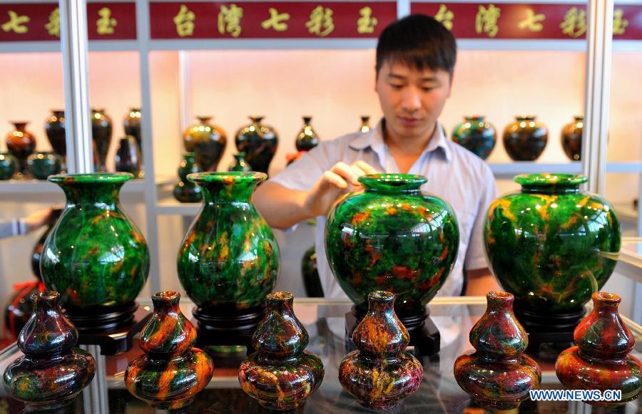 A customer watches jade products at Kunming International Jewelry Exhibition in Kunming, capital of southwest China's Yunnan Province, Nov. 22, 2012. The five-day exhibition, which has attracted many exhibitors from southeast Asian countries, will last until Nov. 26. (Xinhua/Lin Yiguang) 