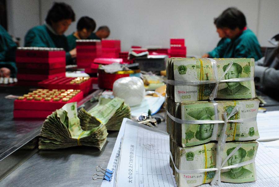 Photo taken on Nov. 18, 2012 shows bundles of sorted-out one-yuan notes at the cash center of the Taicang Public Bus Company in Taicang, east China's Jiangsu Province. Each day, staff members at the cash center of the Taicang Public Bus Company need to sort out notes and coins collected from all bus fare boxes of the company. It takes four hours on average to finish a day's work: the total earnings of 52 bus lines. (Xinhua/Ji Haixin) 