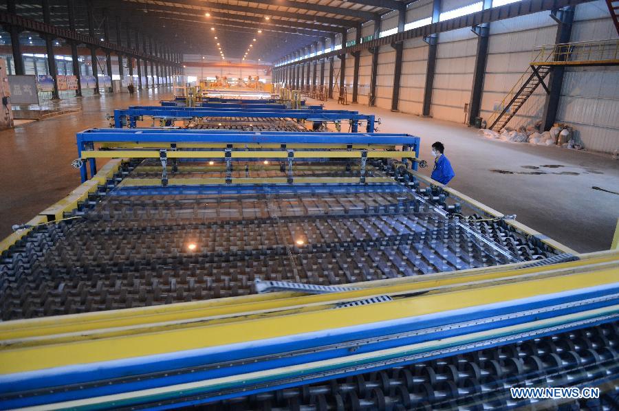 Workers observe the production line in Hongyu energy company in Zhangshu, east China's Jiangxi Province, Nov. 22, 2012. The company has invested 350 million yuan (56.1 million dollars) and built the largest energy efficiency glass production line in China. (Xinhua/Zhou Mi)