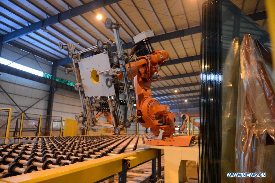 Robots work on the production line in Hongyu energy company in Zhangshu, east China's Jiangxi Province, Nov. 22, 2012. The company has invested 350 million yuan (56.1 million dollars) and built the largest energy efficiency glass production line in China. (Xinhua/Zhou Mi) 