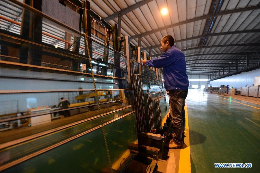 A man works on the production line in Hongyu energy company in Zhangshu, east China's Jiangxi Province, Nov. 22, 2012. The company has invested 350 million yuan (56.1 million dollars) and built the largest energy efficiency glass production line in China. (Xinhua/Zhou Mi) 
