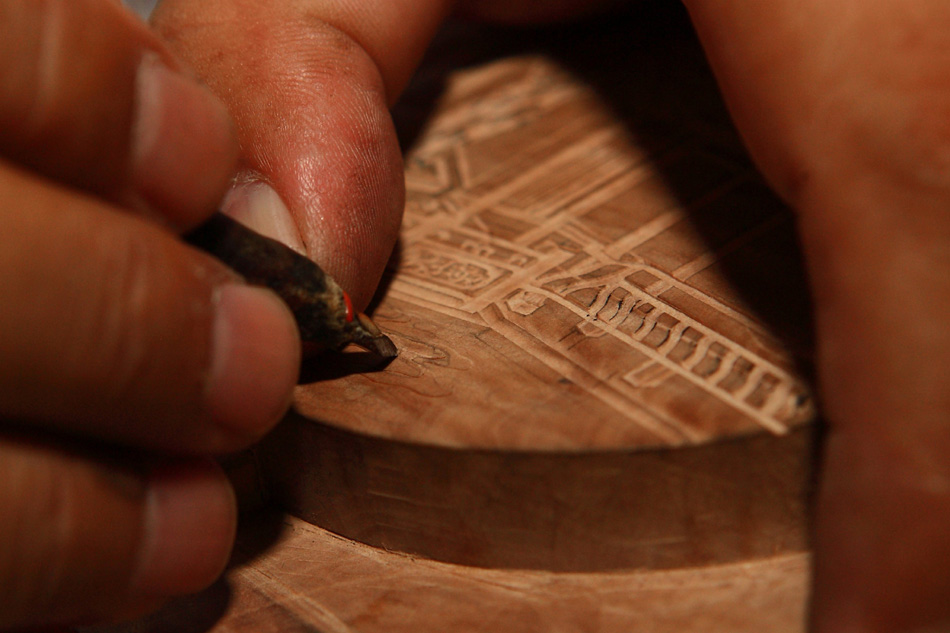Xiang Shengli works on a piece of pattern mould of inksticks in Shexian County of east China's Anhui Province, Aug. 8, 2012. (Xinhua/Xu Zijian)