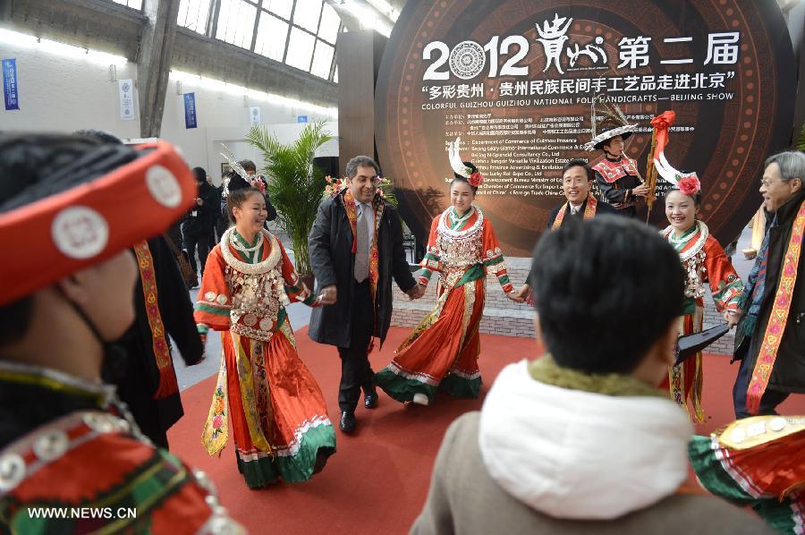 Guests dance with folk artists from southwest China's Guizhou during the show of Guizhou National Folk Handicrafts in Beijing, capital of China, Nov. 21, 2012. (Xinhua/Li Jundong) 