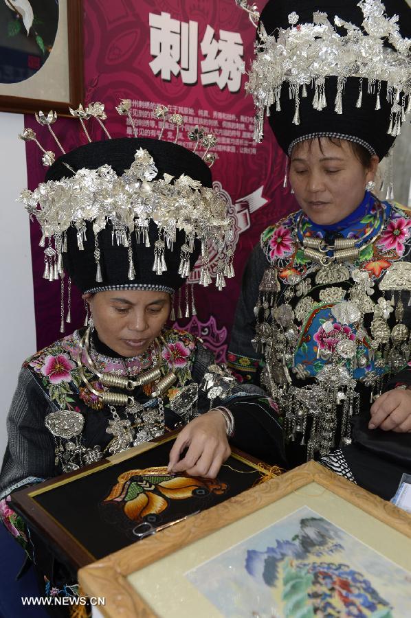 Folk artists from southwest China's Guizhou present the embroidery skills of silver during the show of Guizhou National Folk Handicrafts in Beijing, capital of China, Nov. 21, 2012. (Xinhua/Li Jundong) 