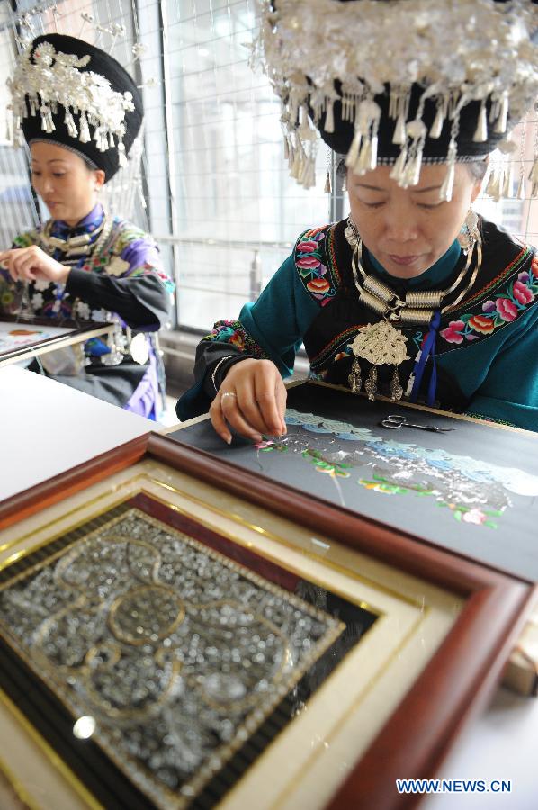 Contestant make embroidery with the style of Miao ethnic group during a competition showcasing handmade craftwork in Guiyang, capital of southwest China's Guizhou Province, Nov. 22, 2012. Some 200 craftsmen showed their skills in the event where exhibited over 570 creations of silverware, batik fabric, embroidery and traditional costumes. The three day competition kicked off here Wednesday. (Xinhua/Ou Dongqu) 