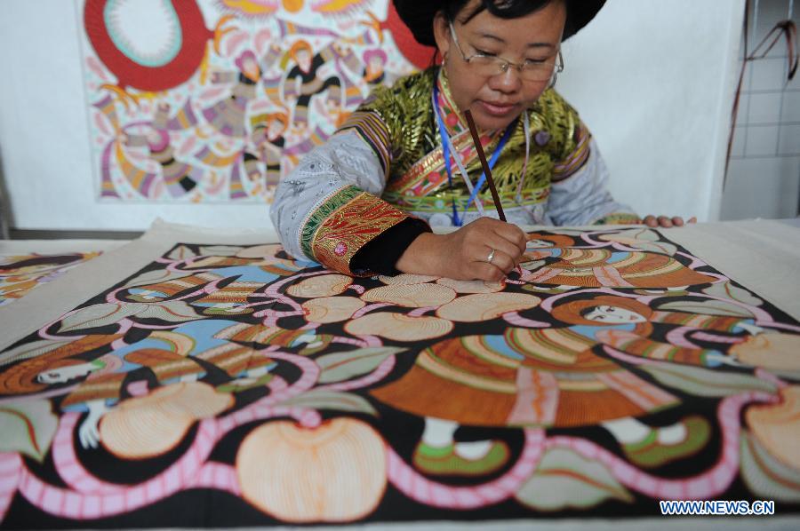 A contestant colours a painting during a competition showcasing handmade craftwork in Guiyang, capital of southwest China's Guizhou Province, Nov. 22, 2012. Some 200 craftsmen showed their skills in the event where exhibited over 570 creations of silverware, batik fabric, embroidery and traditional costumes. The three day competition kicked off here Wednesday. (Xinhua/Ou Dongqu) 