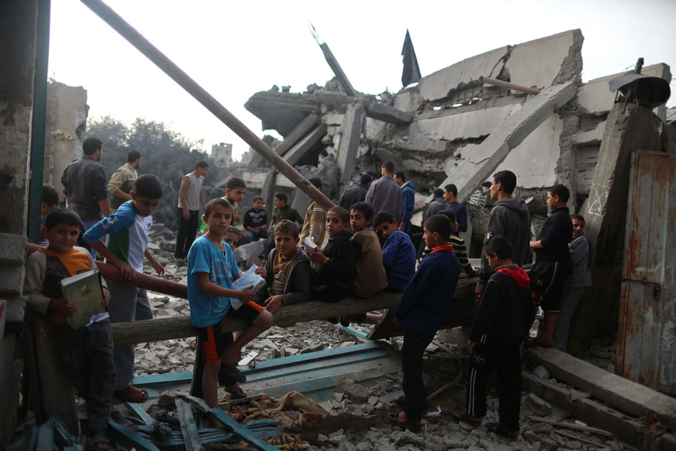 Palestinian children gather at the ruins of a refugee camp in northern Gaza City, on Nov. 17, 2012. (Photo/Xinhua)
