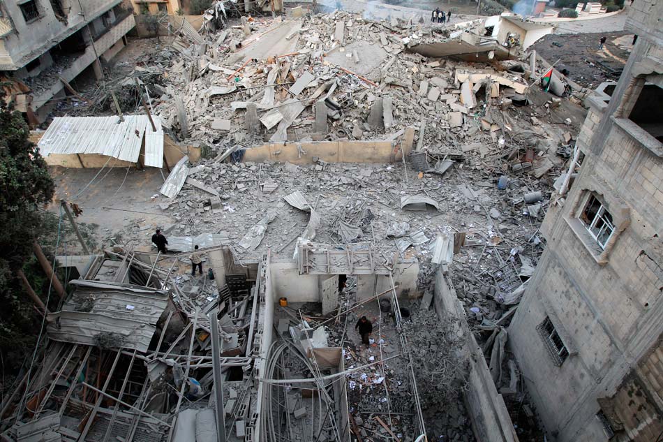 Palestinian security officers inspect the bombed-out building in Gaza City, on Nov. 17, 2012. (Xinhua/AFP)