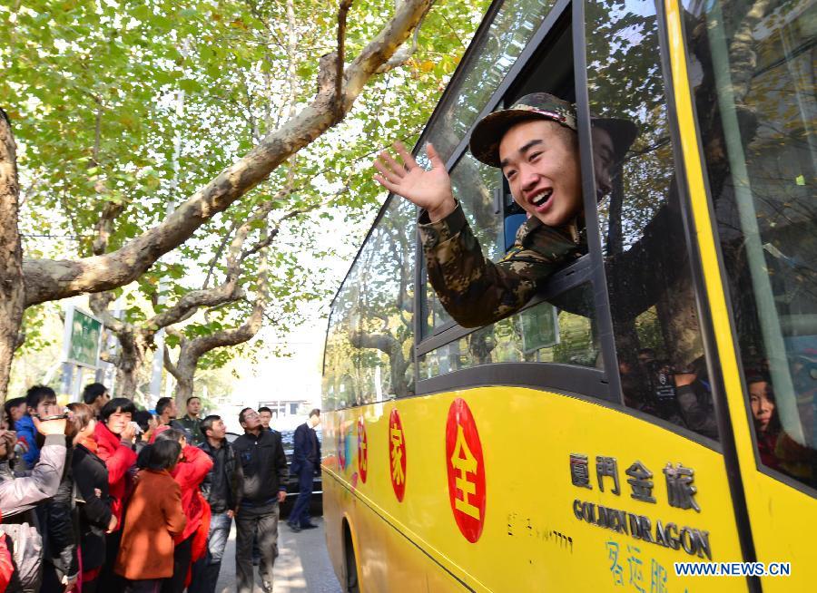 A new military recruit waves farewell to his relatives as he is to leave for southwest China's Tibet Autonomous Region as a new soldier in Jimo City, east China's Shandong Province, Nov. 21, 2012. A total of 55 new soldiers in Jimo have headed to Tibet region ahead of schedule so as to adapt to plateau climate. (Xinhua/Ning Youpeng)