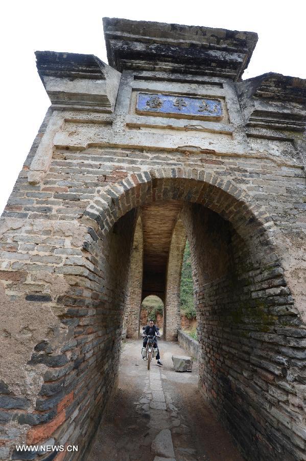 A rider passes the alcove on the Taiping Bridge in Yangcun Village, Longnan County of east China's Jiangxi Province, Nov. 21, 2012. The arch bridge, made of bricks, clay and moorstone, has been set up here for over 200 years. (Xinhua/Song Zhenping) 