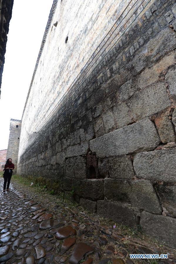 Photo taken on Nov. 21, 2012 shows the outer walls of a walled village in Yangcun Village of Longnan County in Ganzhou City, east China's Jiangxi Province. The Gannan (southern Jiangxi Province) Hakka walled villages, a special architectural type, was included into China's World Cultural Heritage Tentative List on Nov. 17, 2012. The whole structure of the building resembles a small fortified city, containing halls, storehouses and living areas. It is regarded as the "cradle of Hakka". According to official statistics, there are over 600 such buildings in Gannan at present. (Xinhua/Song Zhenping) 