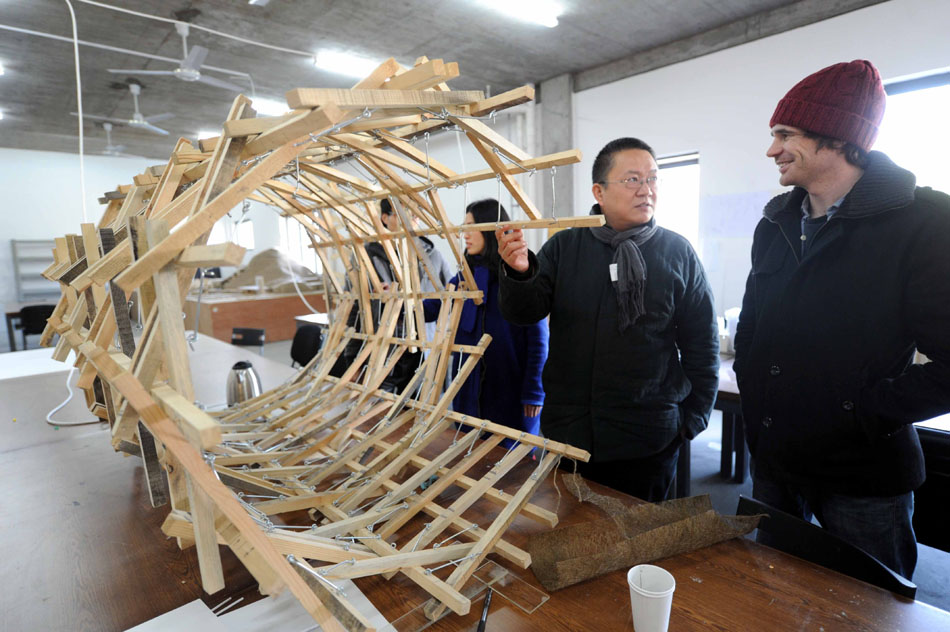 Wang Shu (2nd R) introduces architecture frame to a student at the Xiangshan campus of the China Academy of Art in Hangzhou, capital of east China's Zhejiang Province, Dec. 9, 2011. (Xinhua/Li Xiaoguo)