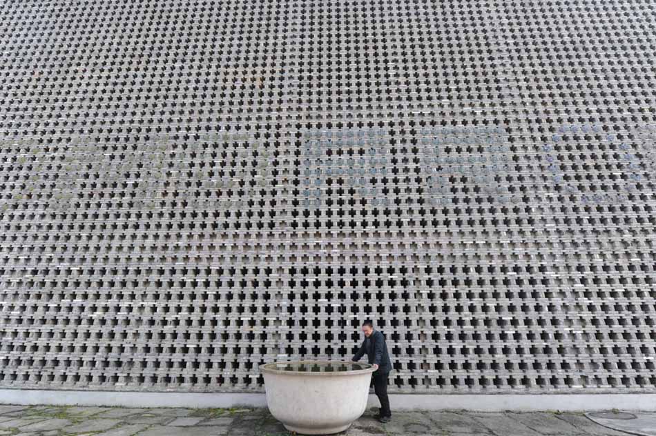 Wang Shu stands in front of a black brick wall at the Xiangshan campus of the China Academy of Art in Hangzhou, capital of east China's Zhejiang Province, Dec. 9, 2011. (Xinhua/Li Xiaoguo)