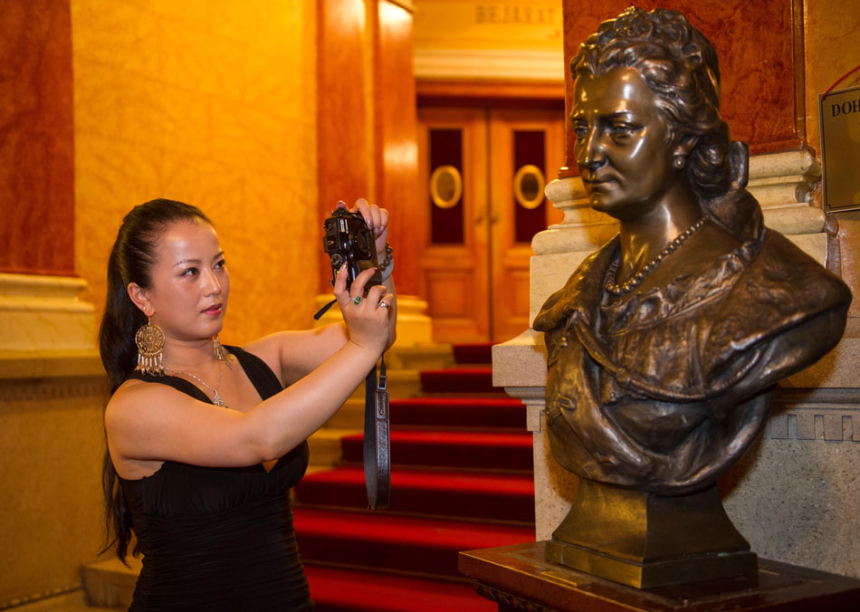 Wang Yige takes pictures at the Hungarian State Opera House in Budapest, Hungary, July 5, 2012. (Xinhua/Luo Xiaoguang)