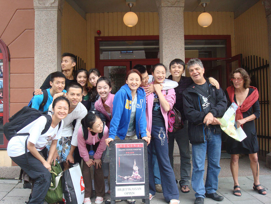 Wang Yuanyuan (C, Front) and her fellow dancers pose with their poster with two audience outside Regina Theatre in Uppsala, Sweden, Aug. 19, 2010. (Xinhua)