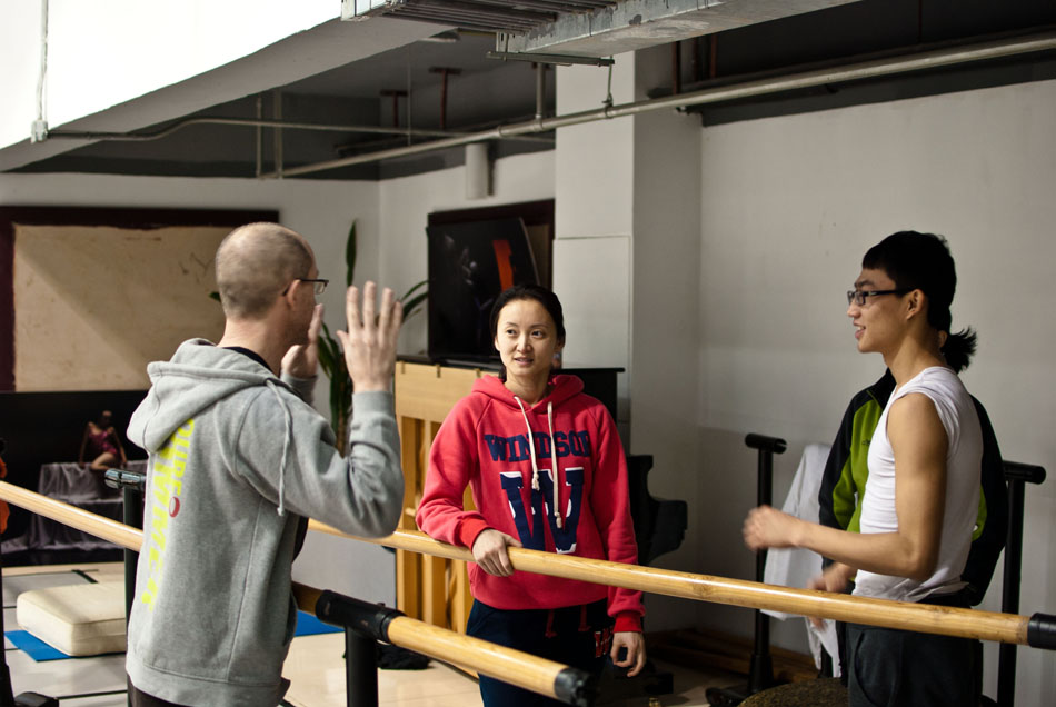 Wang Yuanyuan (C) talks with Tim Rushton (L), the Art Director of Danish Dance Theater, during Tim's training session for the dancers in Beijing Dance Theatre (BDT) in Beijing, capital of China, Jan. 20, 2012. (Xinhua/Li Mangmang)