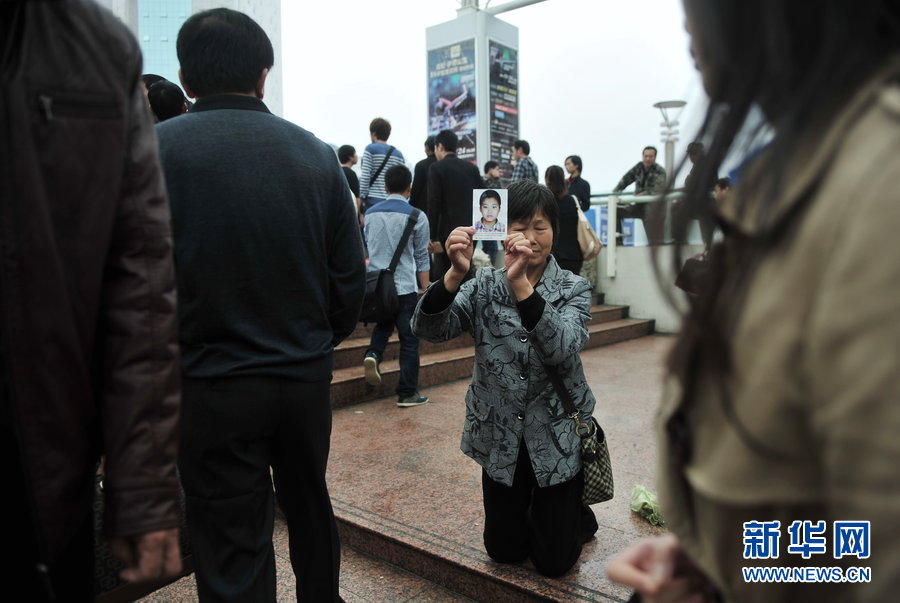 Yu Fanglan, aged over 70, kneels in front of the ticket office of North Coach Station of Fuzhou holding a picture of her lost grandson on Nov. 22, 2012. She was there to ask for help to find her 12-year-old grandson who disappeared three months ago.  Her grandson Zheng Biran went missing after visiting a friend on Aug.26, 2012. (Xinhua)