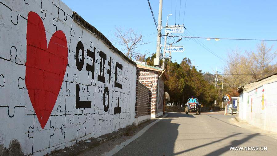 A man drives past a wall with "Love Yeonpyeong Island" written on it on Yeonpyeong island, South Korea, Nov. 23, 2012. A memorial service was held on South Korea's Yeonpyeong island Friday as the country marked the second anniversary of the shelling on the island by the Democratic People's Republic of Korea (DPRK). (Xinhua/Yao Qilin)  