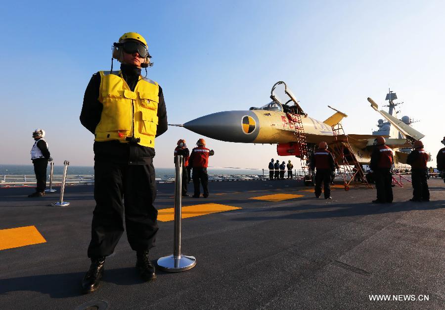 This undated photo shows staff members checking a carrier-borne J-15 fighter jet on China's first aircraft carrier, the Liaoning.(Xinhua/Zha Chunming) 
