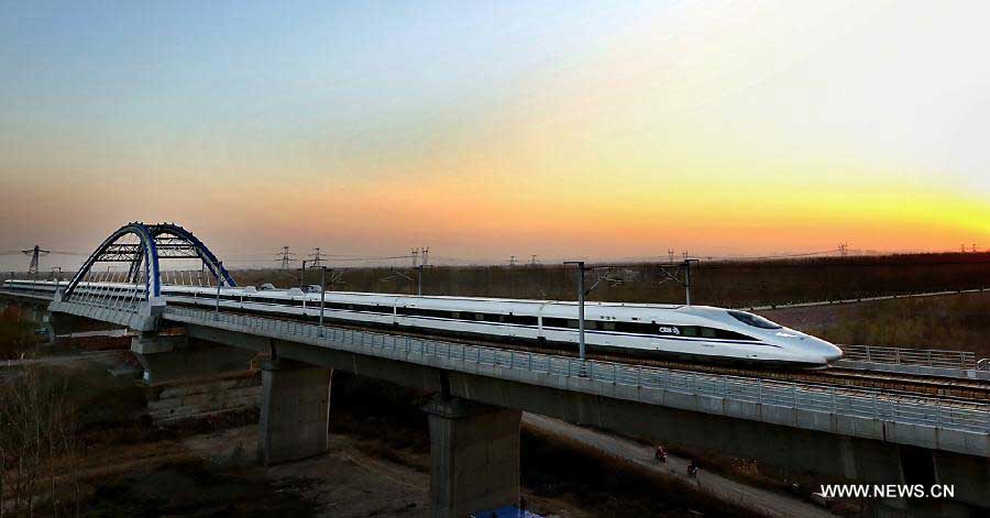 A train runs through the Yellow River Rail-Road Bridge in Zhengzhou City, capital of central China's Henan Province, Nov. 25, 2012. The high-speed rail route from Beijing to the southern Chinese city of Guangzhou will open next month, cutting the 2,200-km journey time by 14 hours, according to the Ministry of Railways. A trial operation along the Beijing-Zhengzhou section, the last part of the route, began on Sunday morning. (Xinhua/Qing Zhu)