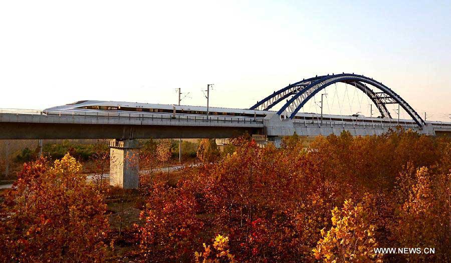 A train runs through the Yellow River Rail-Road Bridge in Zhengzhou City, capital of central China's Henan Province, Nov. 25, 2012. The high-speed rail route from Beijing to the southern Chinese city of Guangzhou will open next month, cutting the 2,200-km journey time by 14 hours, according to the Ministry of Railways. A trial operation along the Beijing-Zhengzhou section, the last part of the route, began on Sunday morning. (Xinhua/Qing Zhu) 
