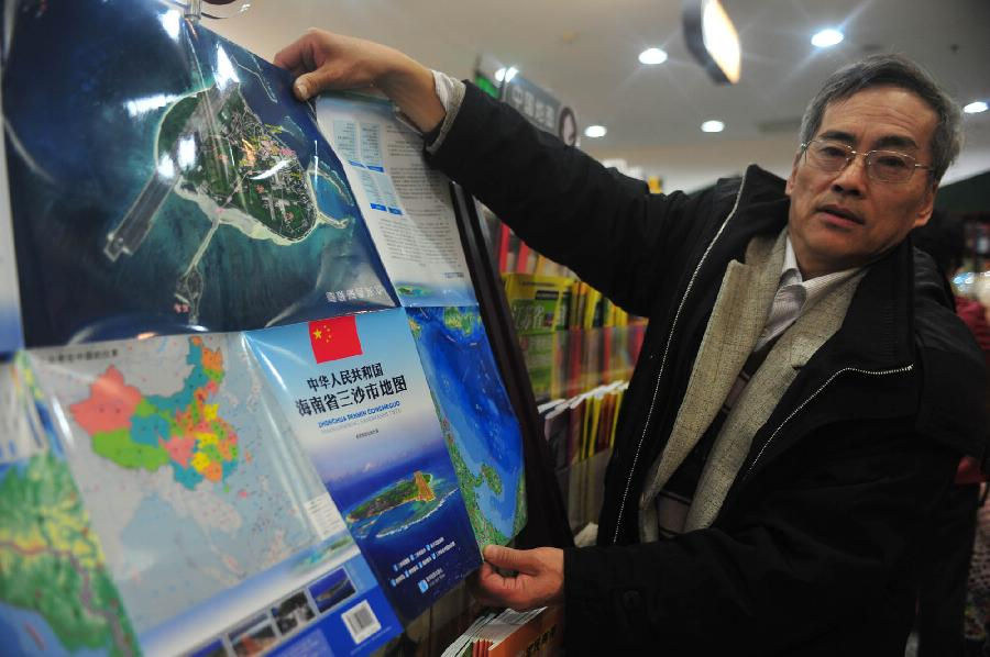 A man presents the map of Sansha city at Xidan Books Building in Beijing, capital of China, Nov. 24, 2012. The first official map of the newly-established Sansha city in south China's Hainan Province was published on Saturday. (Xinhua/Liu Changlong)