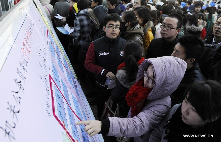 Applicants watch the map of examination rooms of the 2013 civil service exams in Yinchuan, capital of northwest China's Ningxia Hui Autonomous Region, Nov. 25, 2012. More than 1.5 million people took part in the nationwide exams in China to qualify for about 20,000 state civil service posts on Sunday. (Xinhua/Li Ran) 
