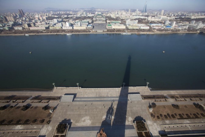 A shadow of the 170-meter Juche Tower is cast over the Taedong River in Pyongyang, DPRK.(Photo/Xinhua)