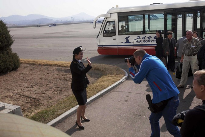 A European passenger photographs a flight attendant of North Korean airline. The flight from Beijing just arrived in Pyongyang. (Photo/Xinhua)