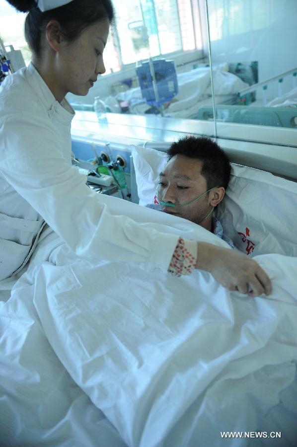Injured miner Shang Yufei (R) receives treatment at a hospital in Liupanshui City, southwest China's Guizhou Province, Nov. 25, 2012. Nineteen miners were confirmed dead, five injured and four others remain trapped after a coal-gas outburst hit the Xiangshui Coal Mine at 10:55 a.m. on Saturday.(Xinhua/Tao Liang) 