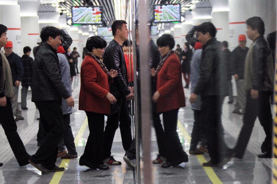 Passengers board a train of Hangzhou Subway Line 1 in Hangzhou, capital of east China's Zhejiang Province, Nov. 24, 2012. Hangzhou Subway Line 1, the first subway in Zhejiang covering a distance of 47.97 kilometers, was put into a trial operation on Saturday after five years of construction. (Xinhua/Wu Huang)  