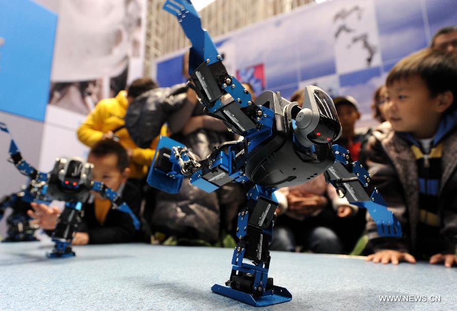 Visitors view robots dancing in a robot show held in Qingdao University, Qingdao, east China's Shandong Province, Nov. 25, 2012. The robot show, the first kind of this exhibition in Shandong, showcased the latest achievement of robot-related technology, involving over 100 exhibits from home and abroad. (Xinhua/Li Ziheng) 